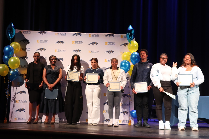 Underclassmen Distinguished Scholars posing with Certificates in front of a Euclid Schools backdrop.