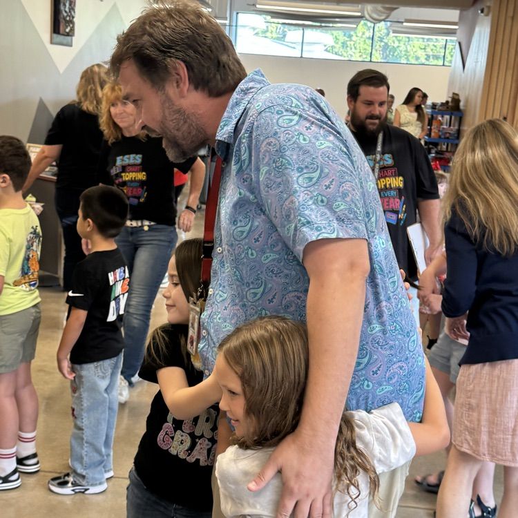 students hugging teacher