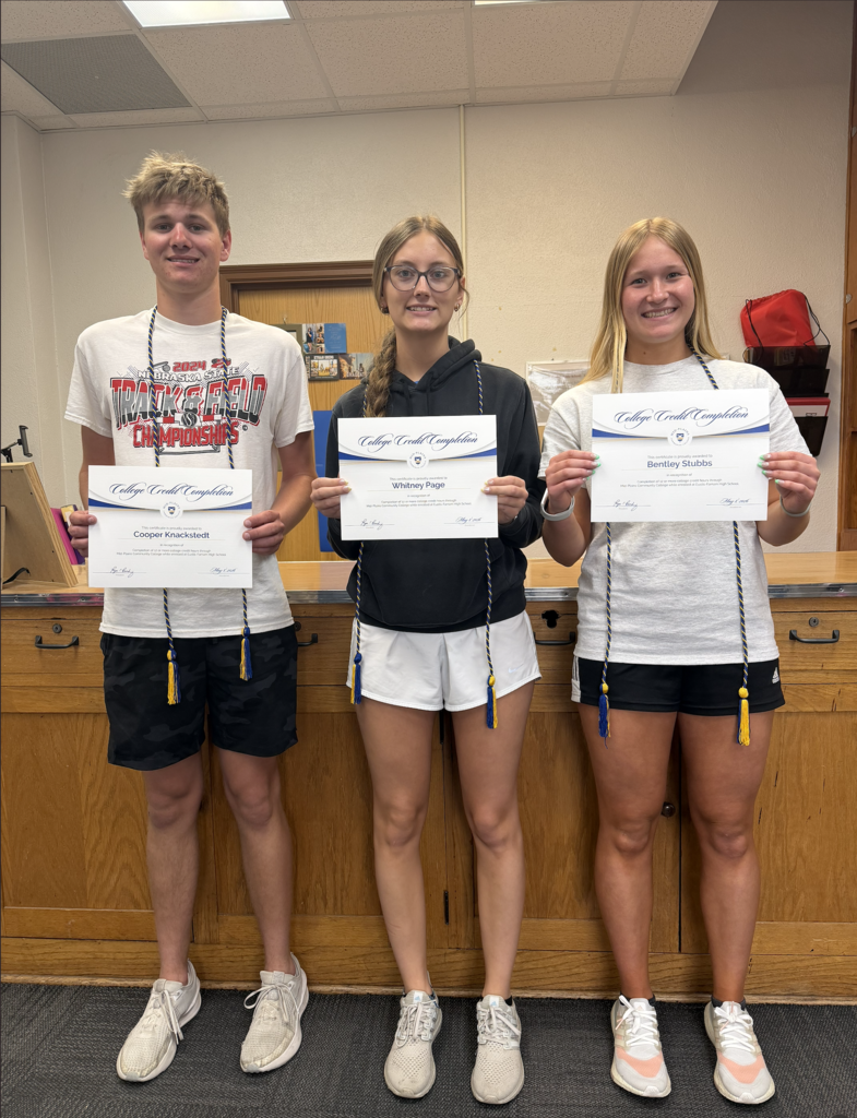 Three students with certificates.