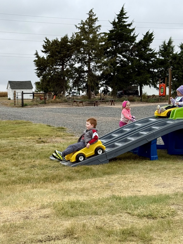 Student riding a toy car