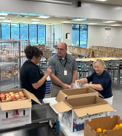 Picture of SNP staff and volunteer prepping meals