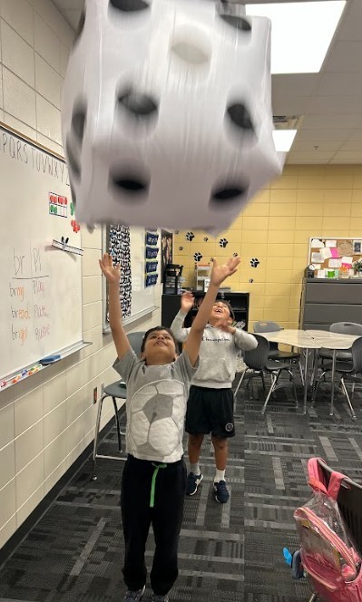 kids tossing dice for math