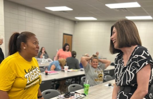 Staff greeting one another and smiling before welcome back meetings