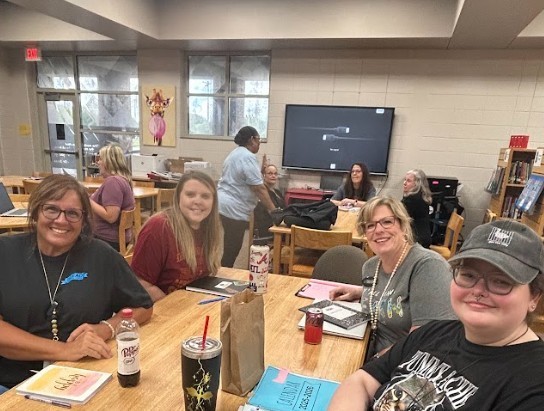 Teachers sitting at table and beginning welcome back meetings