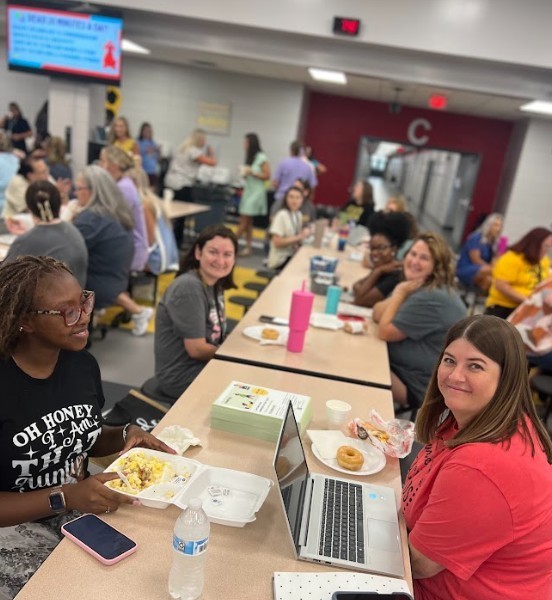 Group of teachers sitting at table with breakfasts and beginning welcome back meetings