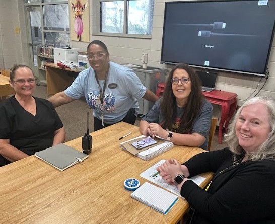 Teachers sitting at table and beginning welcome back meetings