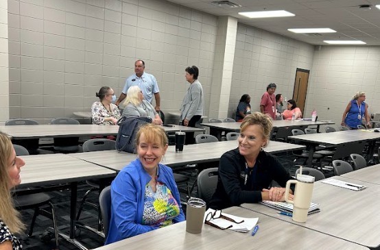 Teachers sitting at table and beginning welcome back meetings