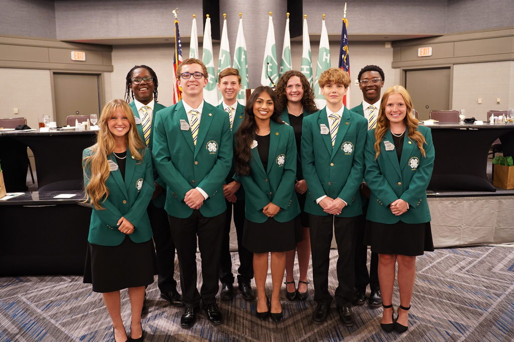Group picture of GA 4-H student leaders in front of 4H flags