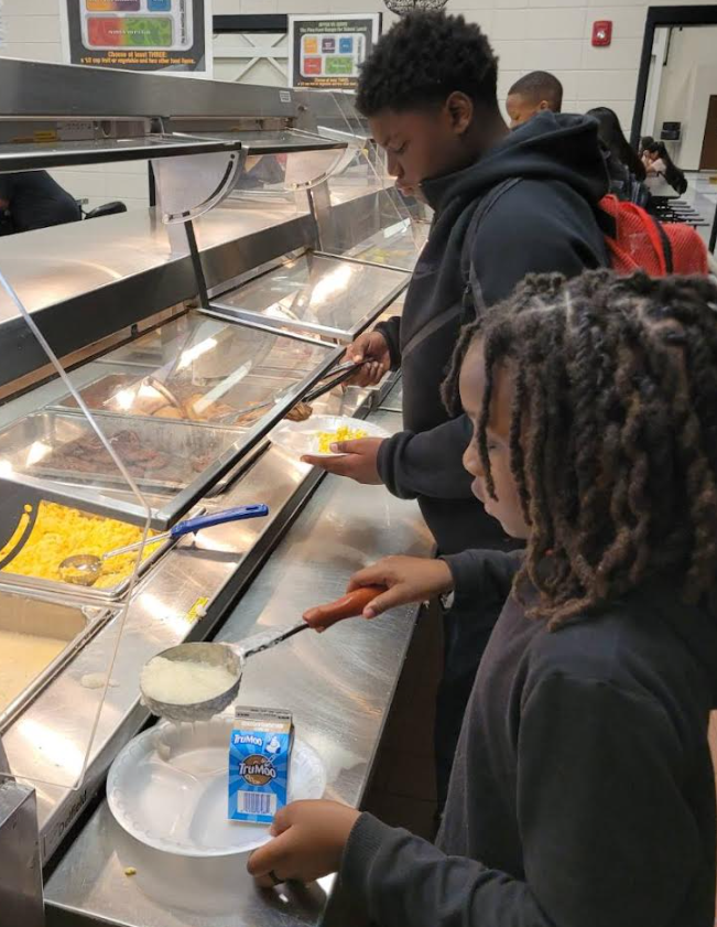 Students in serving line putting breakfast on their plates at Claxton Middle/High School