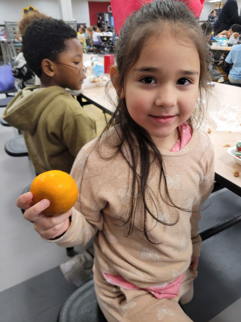 Student holding an Orange
