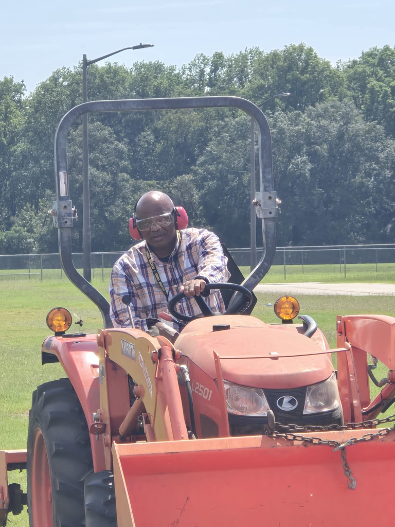 Picture showing 🚜✨ Students in Mr. Turner's Basig Ag class learned how to properly maintain and operate a tractor — and even got behind the wheel to demonstrate their skills! 👩‍🌾👨‍🌾  To top it off, Mr. Curry, our CHS Business teacher, drove a tractor for the VERY first time — and he did a great job! 🙌👏  🐯Proud of our Claxton Tigers reppin’ that Black & Gold 🖤💛  #ClaxtonTigers #AgEducation #HandsOnLearning #BlackAndGoldPride #FutureFarmers #TheDen