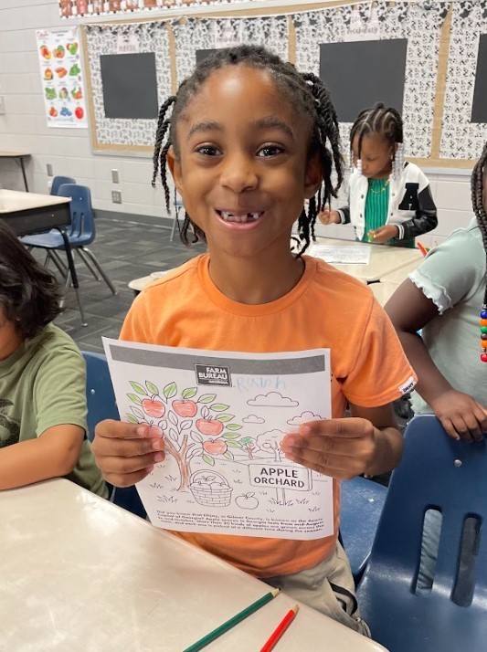 student showing off apple art