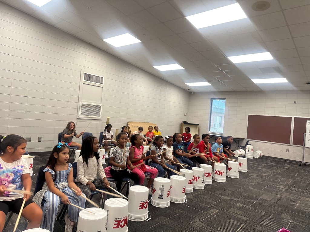students using buckets as drums