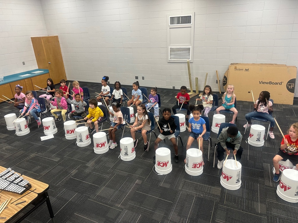 students using buckets as drums