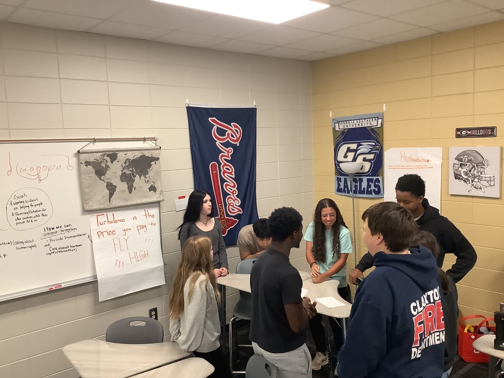 Image showing 📚✨ Coach Lanier’s Government classes have been diving deep into the Executive Branch and the roles of the President! 🇺🇸 As part of their unit on foreign policy, students became leaders of fictional countries 🌍—representing economic aid, military aid, humanitarian aid, and technology. Each country first reflected on its own strengths 💪 and weaknesses 🤔, then worked with others to find ways to cooperate. The ultimate challenge? 🤝 To create a treaty that benefits all four nations—ensuring balance, fairness, and collaboration without one country dominating the rest. To prepare, students explored real-world examples like the Marshall Plan, 9/11 & NATO, and the Lend-Lease Act, connecting history to today’s global relationships. 🌐 We’re so proud of our Tigers for learning how cooperation and diplomacy shape the world! 🐅💛🖤 #ClaxtonTigers #GovernmentClass #ExecutiveBranch #FutureLeaders #ForeignPolicy #Teamwork #LearningByDoing #BlackAndGold