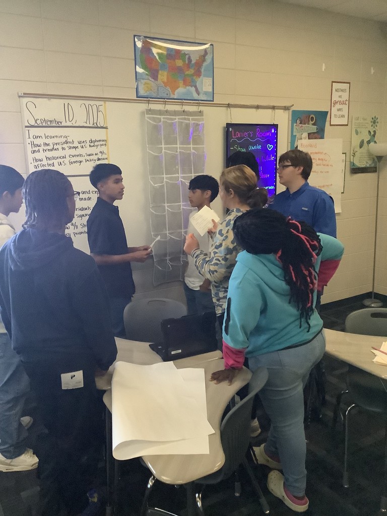 Image showing 📚✨ Coach Lanier’s Government classes have been diving deep into the Executive Branch and the roles of the President! 🇺🇸 As part of their unit on foreign policy, students became leaders of fictional countries 🌍—representing economic aid, military aid, humanitarian aid, and technology. Each country first reflected on its own strengths 💪 and weaknesses 🤔, then worked with others to find ways to cooperate. The ultimate challenge? 🤝 To create a treaty that benefits all four nations—ensuring balance, fairness, and collaboration without one country dominating the rest. To prepare, students explored real-world examples like the Marshall Plan, 9/11 & NATO, and the Lend-Lease Act, connecting history to today’s global relationships. 🌐 We’re so proud of our Tigers for learning how cooperation and diplomacy shape the world! 🐅💛🖤 #ClaxtonTigers #GovernmentClass #ExecutiveBranch #FutureLeaders #ForeignPolicy #Teamwork #LearningByDoing #BlackAndGold