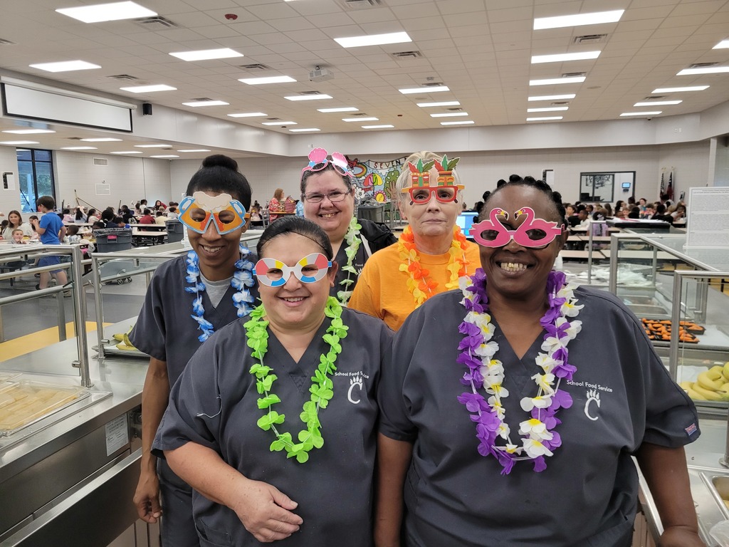 School nutrition staff members posing with leis and fun glasses.