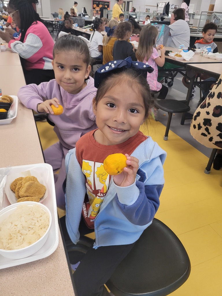 Elementary students holding a Kishu mandarin.