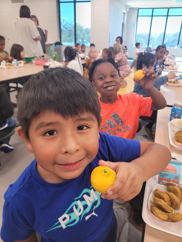 Elementary students holding a Kishu mandarin.
