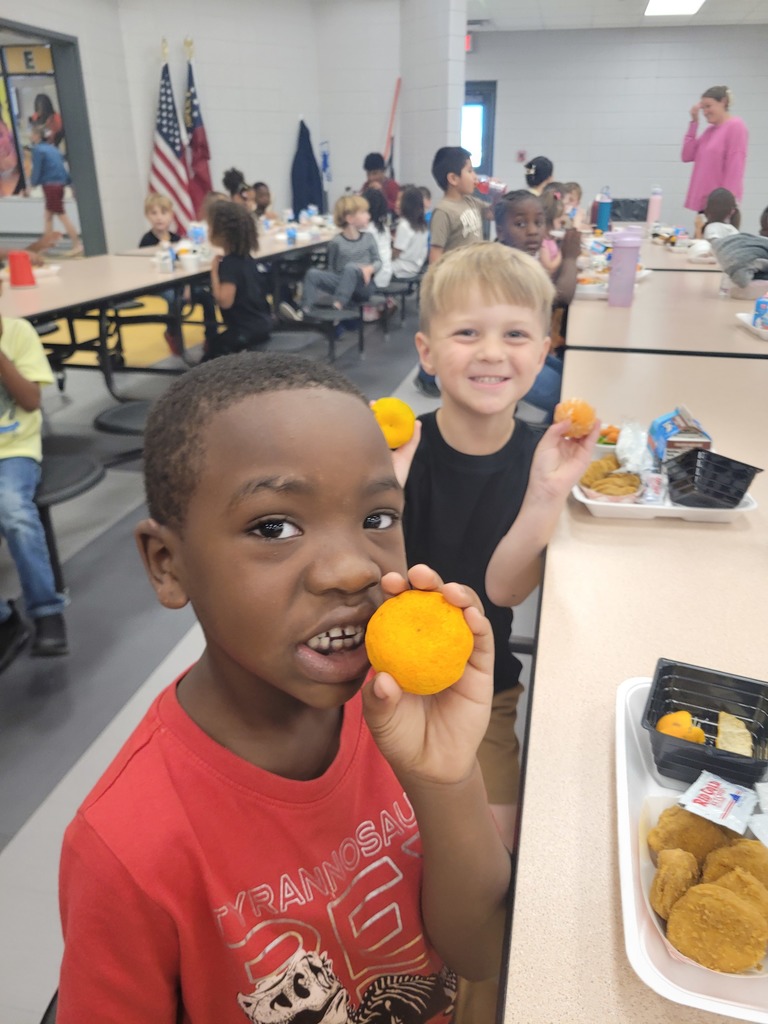 Elementary students holding a Kishu mandarin.
