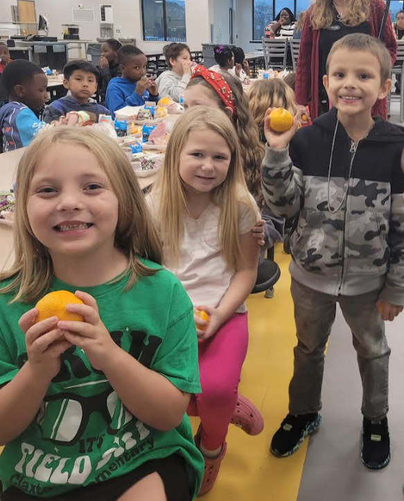 Students holding their citrus fruits.