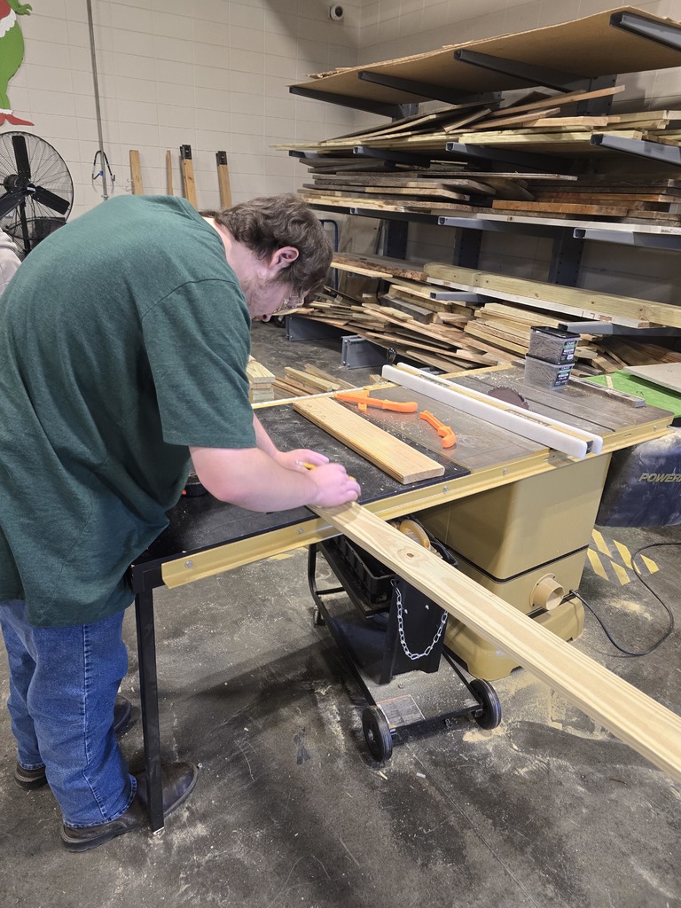 Image showing 🎄 Ag Mech Students Building Holiday Cheer! 🚂 Mr. Turner's Ag Mech 1 class students are hard at work, applying their skills to build a special wooden train for Christmas!  This project is a great way for students to master essential skills, including woodworking techniques, effective communication for collaboration, and the importance of using proper PPE (Personal Protective Equipment) to ensure safety.  Great job blending craftsmanship with holiday spirit! 🖤💛  #TheDEN #AgMech1 #Woodworking #CTAE #ShopClass #ChristmasProject #SafetyFirst 🛠️