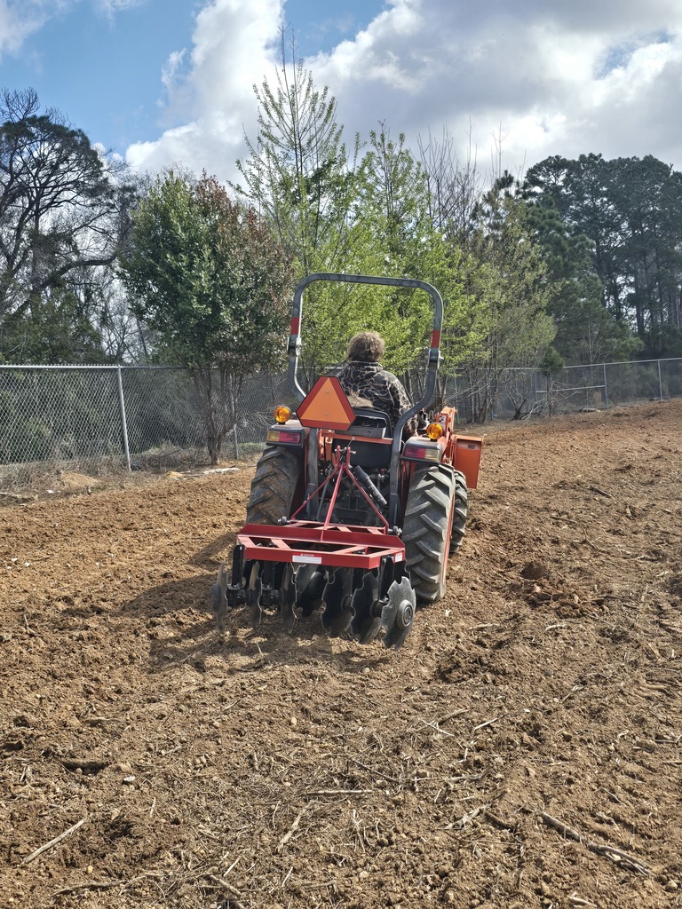 Image showing 🚜 Breaking Ground: Ag Mech 2 is Heading to the Field! 🌱  Spring is just around the corner, and our Ag Mechanics 2 students are making sure The DEN is ready! This week, students moved from the classroom to the tractor seat to begin prepping the soil for our springtime grass planting.  This hands-on lesson focused on the mastery of the three-point harrow. Operating a tractor while pulling an implement requires a high level of coordination and a "safety-first" mindset. Our Tigers aren't just driving; they are learning the technical side of agriculture, including:  Safe Operating Procedures: Mastering the "rules of the road" for agricultural machinery.  Hitch Mastery: Identifying tractor parts and the complex mechanics of attaching and removing implements.  Precision Prep: Using the harrow to break ground effectively for optimal planting conditions.  We are proud to see our students applying their classroom knowledge to real-world tasks! 🐯🖤💛  #TheDEN #AgMechanics #HandsOnLearning #FutureFarmers #TractorSafety #ClaxtonHigh