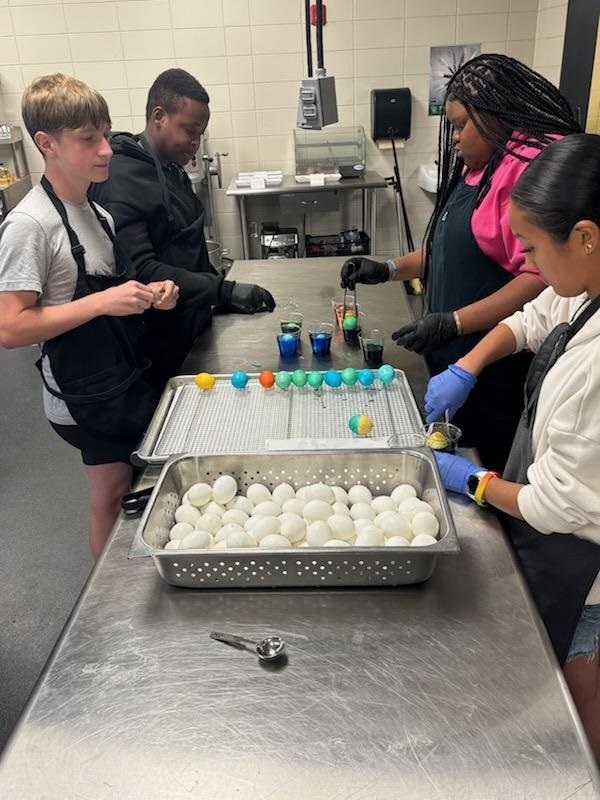 Students in the Year 1 Culinary Course helping the CMS-CHS staff dye eggs for lunch on Friday.