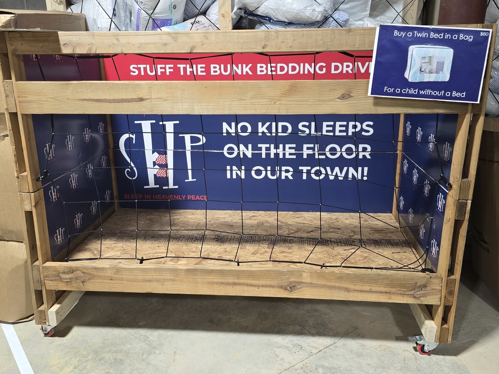 Image showing 🛏️ No Kid Sleeps on the Floor: Claxton FFA Makes an Impact in Macon! 🐯  Our Claxton FFA Chapter recently returned from a powerful five-day journey at the Georgia FFA State Convention in Macon. While the week was filled with leadership workshops and exploration, the highlight was a massive community service initiative that hit close to home.  In partnership with Sleep in Heavenly Peace, our very own Preston Waters, Mason Sapp, and Garrison Sapp joined forces with FFA members from across Georgia to build over 1,000 beds for children in need.  The Mission in Action:  Precision & Skill: Students measured, cut, and sanded lumber to create high-quality bed frames.  Teamwork: Working alongside peers from all over the state to meet an ambitious production goal.  Heart: Knowing that their hard work ensures a child in Georgia won't have to sleep on the floor tonight.  We are incredibly proud of these young men for representing Evans County with such grit and compassion. They didn't just attend a convention; they built a legacy! 🖤💛  #TheDEN #GeorgiaFFA #StateConvention #SleepInHeavenlyPeace #ServiceAboveSelf #ClaxtonFFA