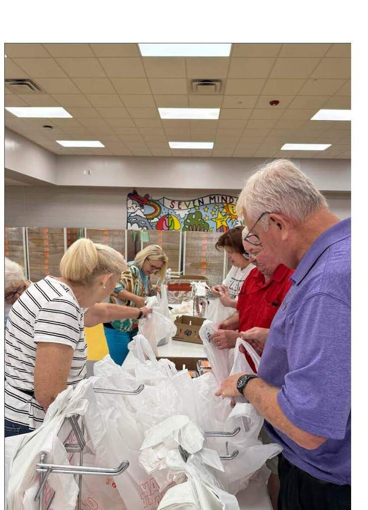 Community volunteers helping pack meals for the summer program. 