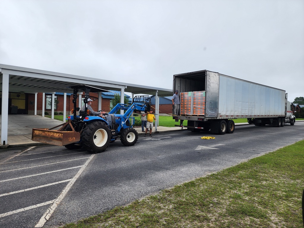 Maintenance staff helping unload breakfast boxes for the summer program.