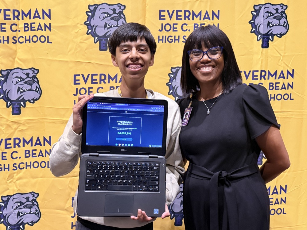 Jean Paul and Dr. Donaldson - Vu Scholarship winner holding his laptop with his amoutn of $4,083,291.