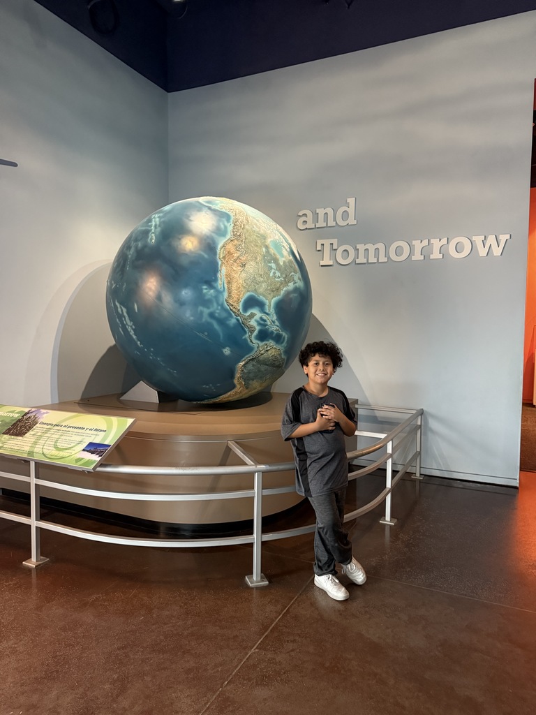 Student in front of a globe.