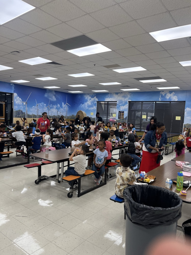 Staff sitting with students during grandparents and grand friends day.
