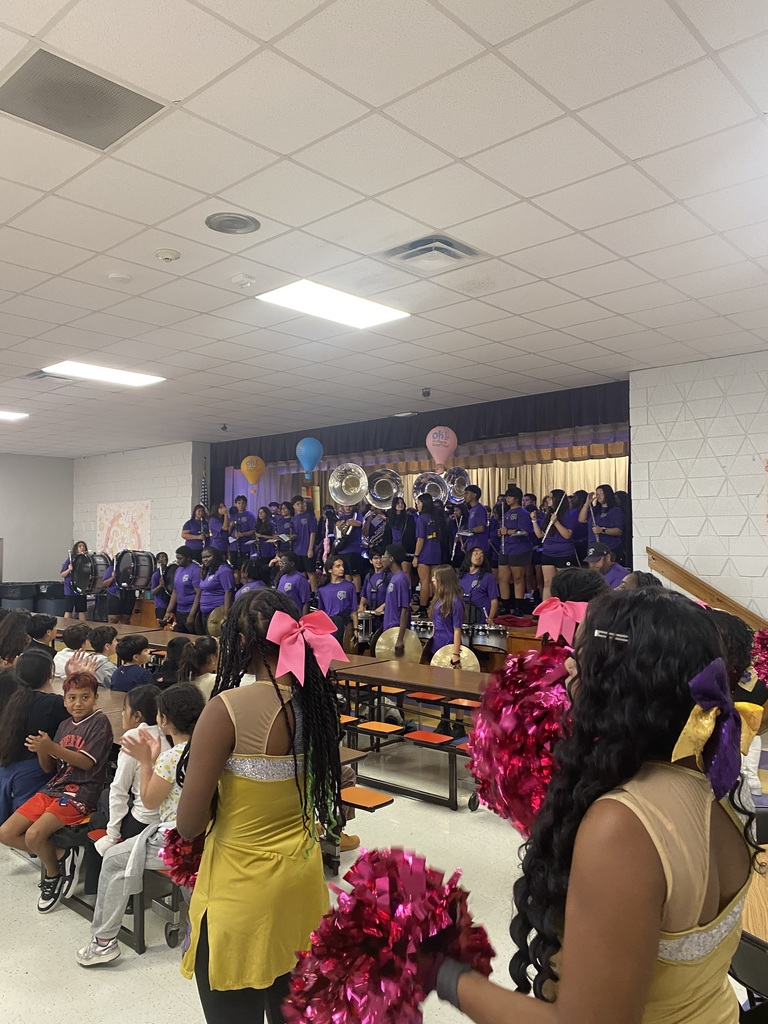 Band members playing a song and the color guard dancing.