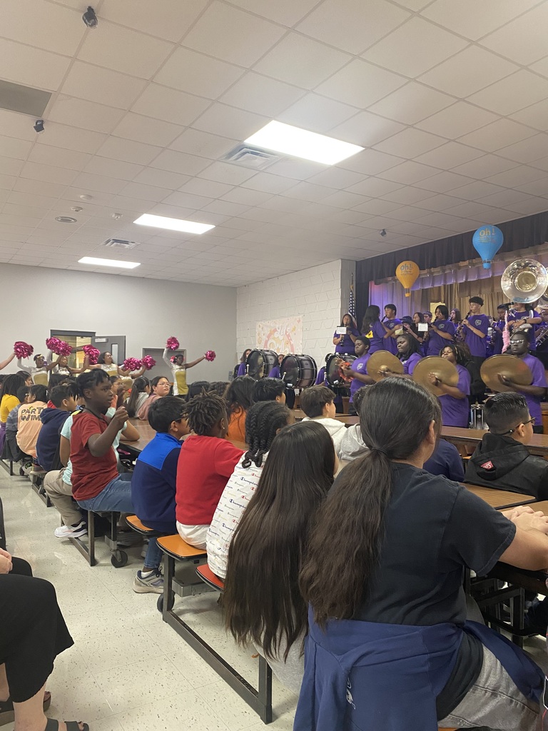 Band members playing a song and the color guard dancing.