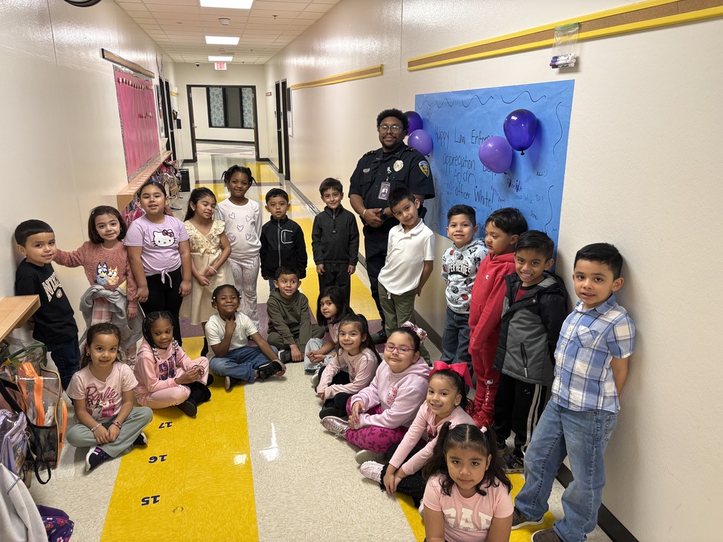 officer white posing with students in front of appreciation poster