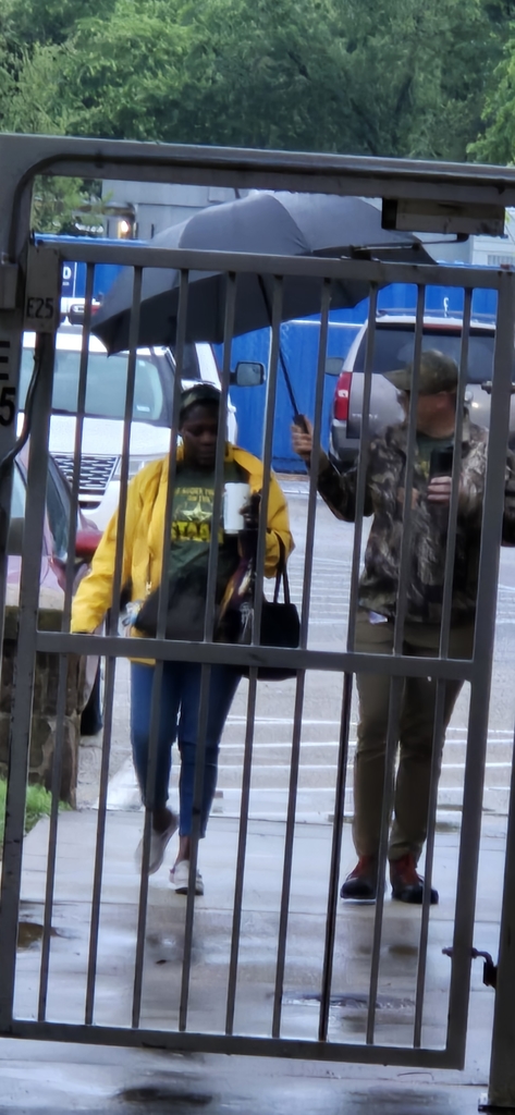 Hommel Principal, Mr. Seals  offering to cover staff from the rain as they walk from their cars. However, there's always that one adult who still wants to splash in the puddles! 
