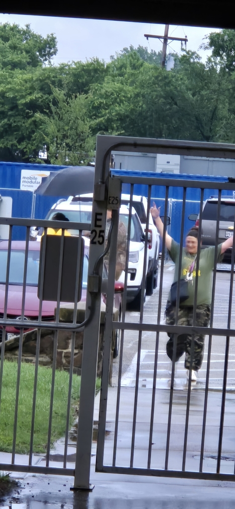 Hommel Principal, Mr. Seals  offering to cover staff from the rain as they walk from their cars. However, there's always that one adult who still wants to splash in the puddles! 