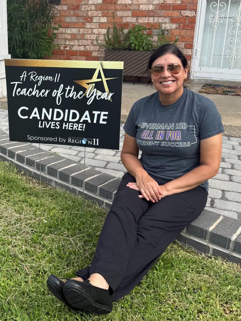 Mrs. Rayman is sitting next to her Teacher of the Year yard sign.