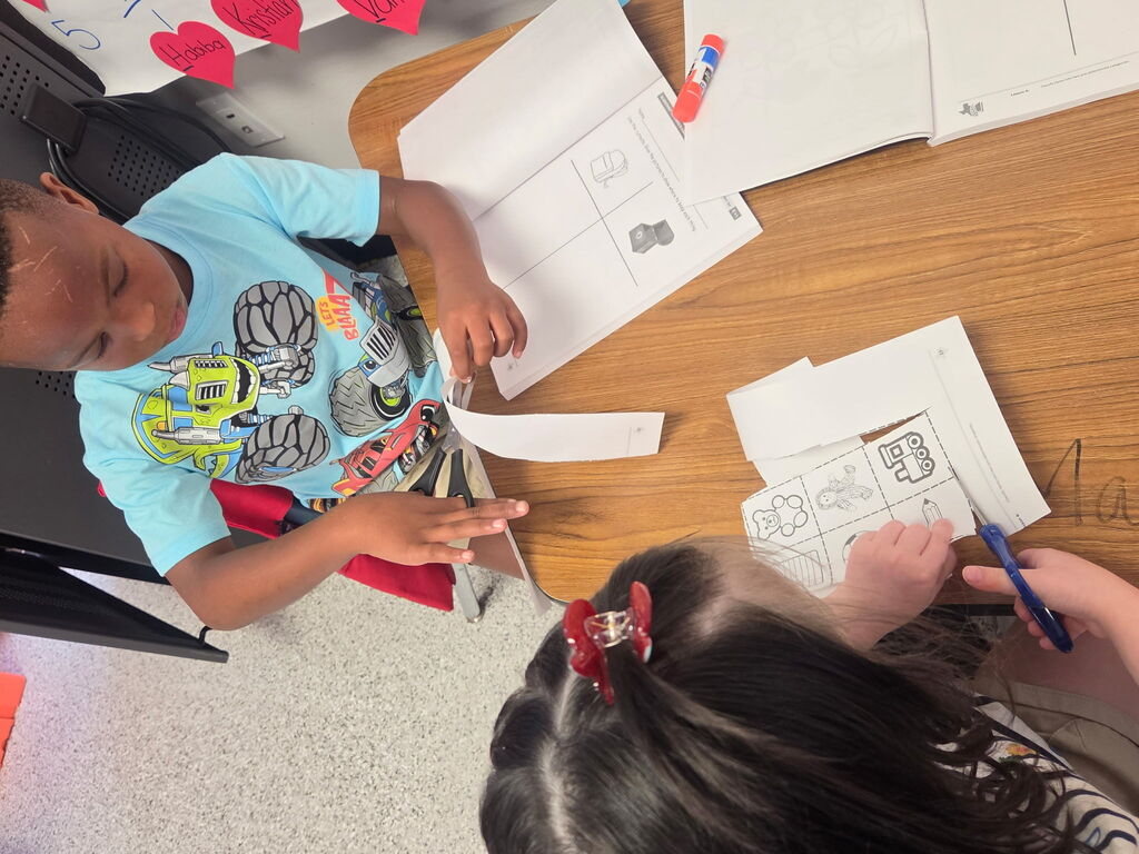 Students are cutting paper. 