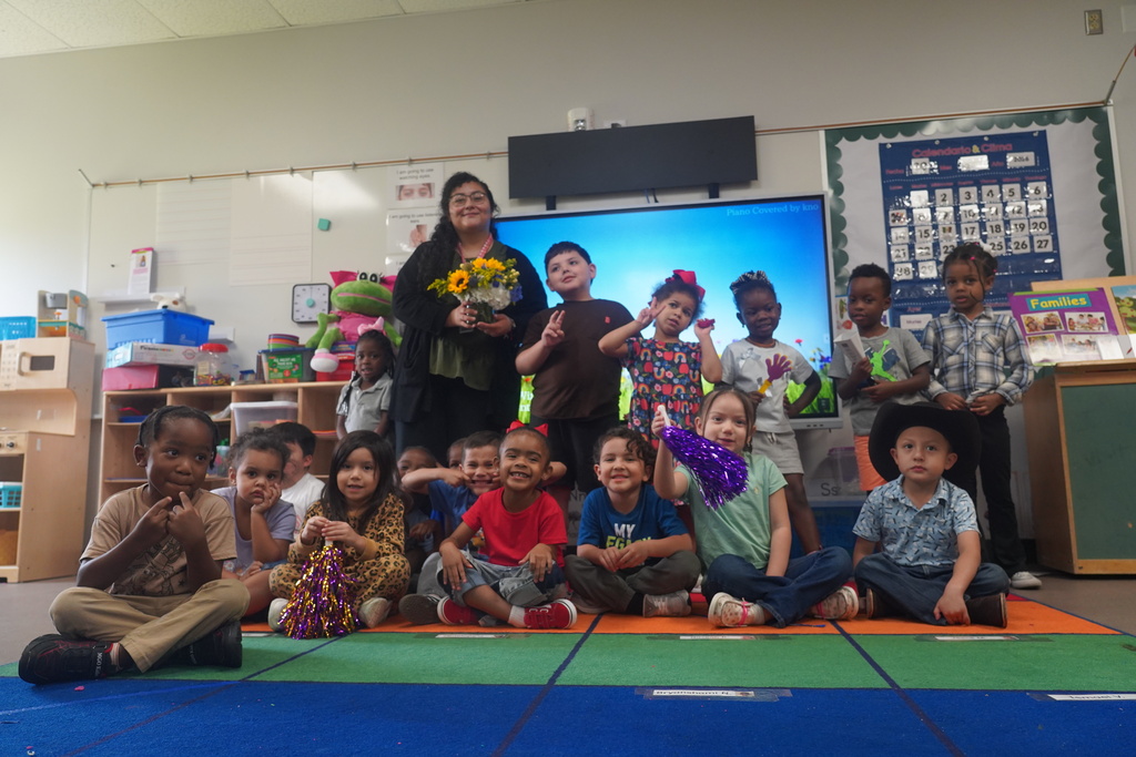 Everman ISD+Adriana Escobedo taking a picture with her students at Dan Powell Early Learning Academy 