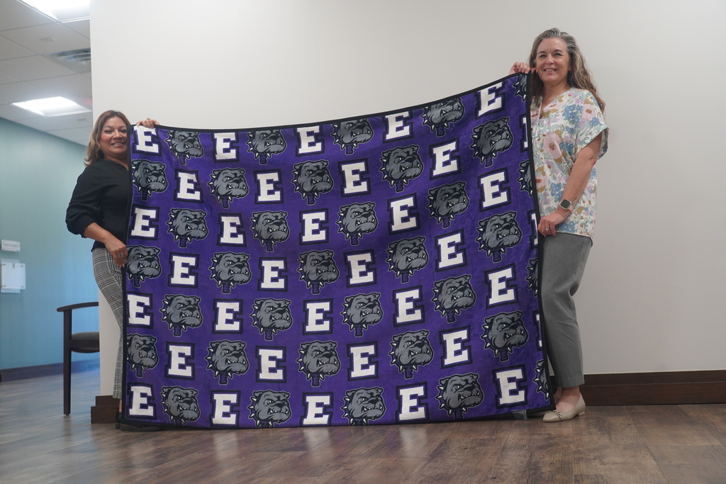 Everman ISD+Two Admin showing off how the blanket looks on each side 