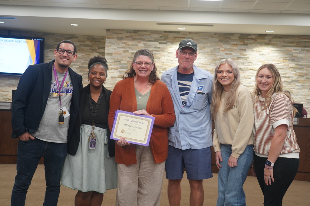 Everman ISD+ picture of staff member michelle Strachan and her family with E.Ray staff members celebrating Michelle's Staff spotlight award