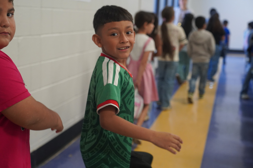 Everman ISD+ kid posing for red ribbon week picture with soccer jersey