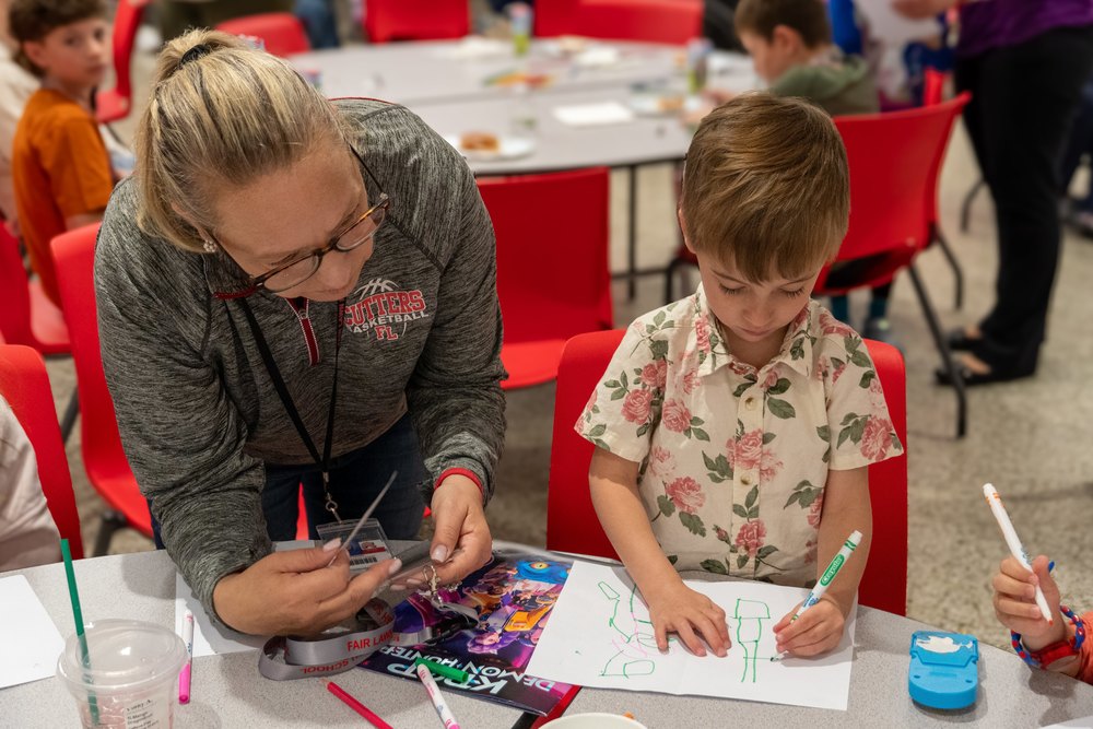 teacher and kid work on drawing