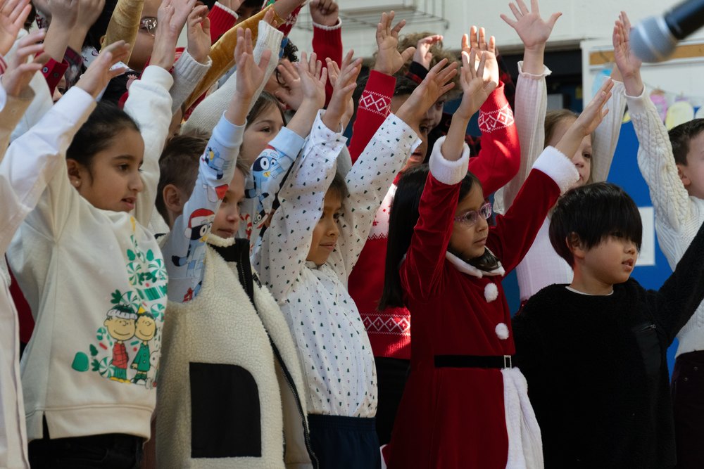 students raise their hands at a concert