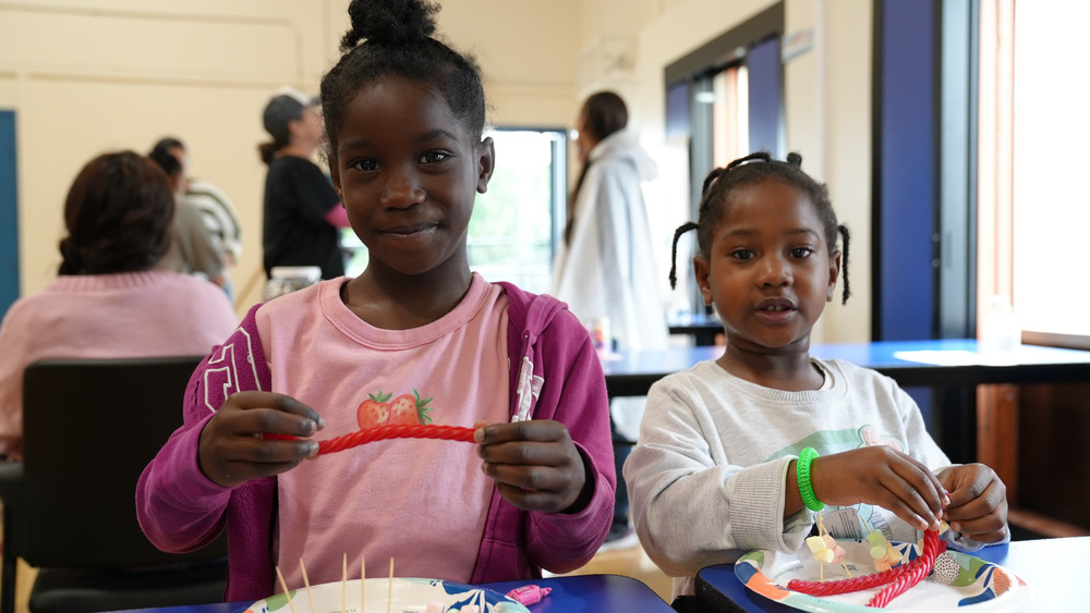 Two girls smiling engaging in activities in the STEAM family night.