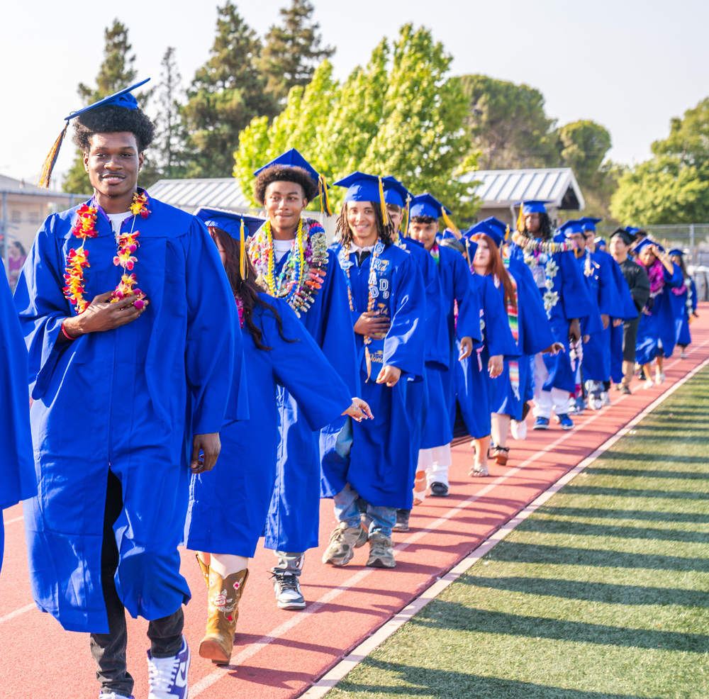 Sem Yeto graduates marching toward the graduation lines.