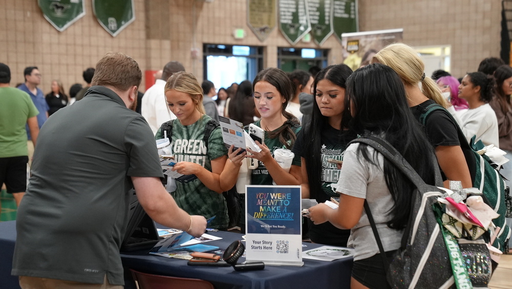 A group of high school students visiting a booth at the college fair at Rodrigues High School